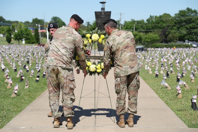 Maj. Gen. JP McGee and Sgt. Maj. Jason Buda lifts the Memorial Wreath, placing it at the base of the Eternal Flame Monument.