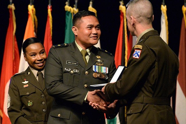Maj. Dian Dessiawan Setyadi of Indonesia receives the Command and General Staff College International Graduate Badge from Maj. Gen. Donn Hill, CGSC deputy commandant, assisted by Army University Command Sgt. Maj. Faith Alexander, left, during the badge presentation ceremony June 17 at the Lewis and Clark Center. Photo by Prudence Siebert/Fort Leavenworth Lamp