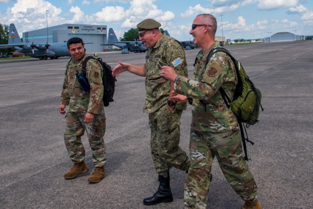 Uruguayan Army Maj. Gen. Hugo Rebollo, U.S. Air Force Col. Tom Olander and U.S. Air Force Maj. Jaime Zambrano discuss tactical airlift operations at the 103rd Airlift Wing in Windsor Locks, Conn. on June 15, 2021. The visit was part of a bilateral State Partnership Program engagement.