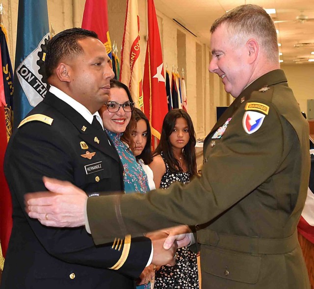 Maj. Gen. Chris Mohan, commanding general, U.S. Army Sustainment Command, and senior mission commander, Rock Island Arsenal, Illinois, congratulates Chief Warrant Officer 3 Javish Hernandez, after awarding him the Meritorious Service Medal during...