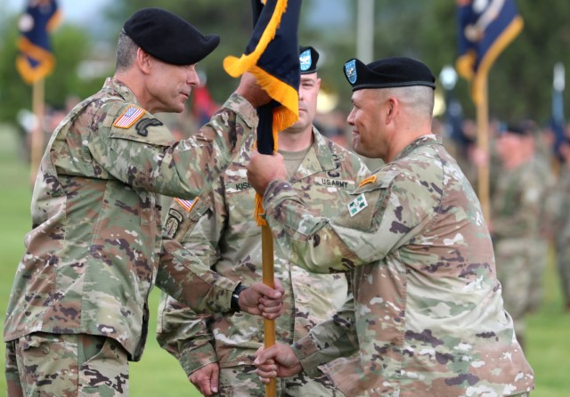 Col. Scott Knight, outgoing commander of 2nd Stryker Brigade Combat Team, 4th Infantry Division, passes the brigade colors to Maj. Gen. Matthew MacFarlane, commander of 4th Inf. Div. during a change of command ceremony June 25, 2021 at Fort Carson, Colo. The change of command ceremony is a time-honored tradition in which the outgoing commander formally transfers their authority to the incoming commander. (U.S. Army photo by Sgt. Gabrielle Pena)