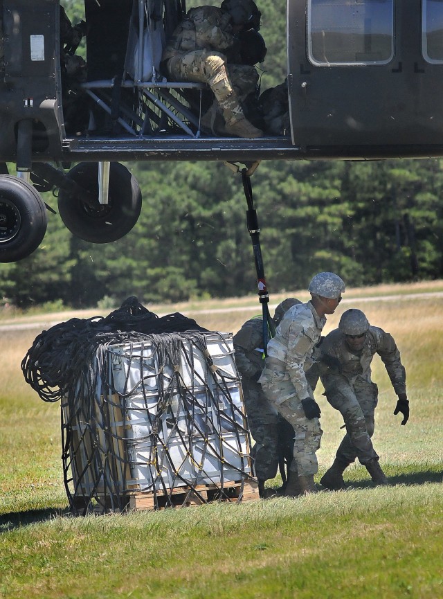 Advanced individual training Soldiers move toward safety after connecting the load to a Black Hawk helicopter during sling load training June 17 at McLaney Drop Zone. The Soldiers are 89B Ammunition Specialist Course students.