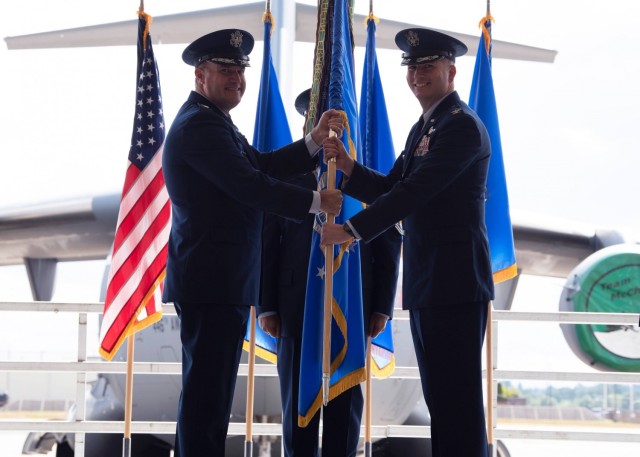 U.S. Air Force Maj. Gen. Kenneth T. Bibb Jr., 18th Air Force commander, presents Col. David A. Fazenbaker, 62nd Airlift Wing commander, with the 62nd AW’s guidon during a change of command ceremony at Joint Base Lewis-McChord, Washington, June...
