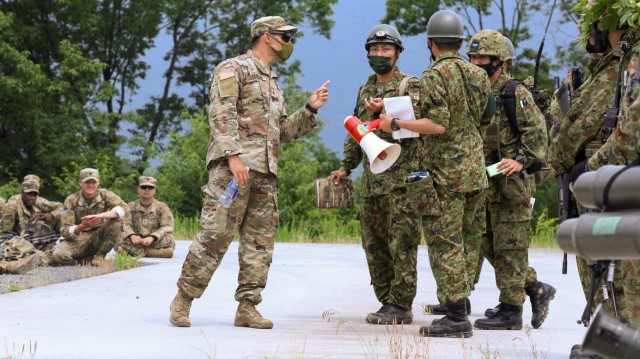 U.S. Army Staff Sgt. James Hankins, assigned to U.S. Army Japan, translates between Soldiers of 1st Battalion, 28th Infantry Regiment “Black Lions,” 3rd Infantry Division, and members of the Japan Ground Self-Defense Force’s 15th Rapid Deployment Regiment June 25, 2021, during bilateral training as part of exercise Orient Shield 21-2 on Aibano Training Area, Japan. Orient Shield is the largest U.S. Army and Japan Ground Self-Defense Force bilateral field training exercise being executed in various locations throughout Japan to enhance interoperability and test and refine multi-domain and cross-domain operations.