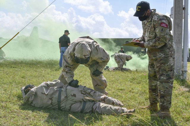 Sgt. 1st Class Elijah Williamson, USAMTEAC Test Officer, takes notes as a test player practice administering the ROCS auto-injector on a simulated casualty.