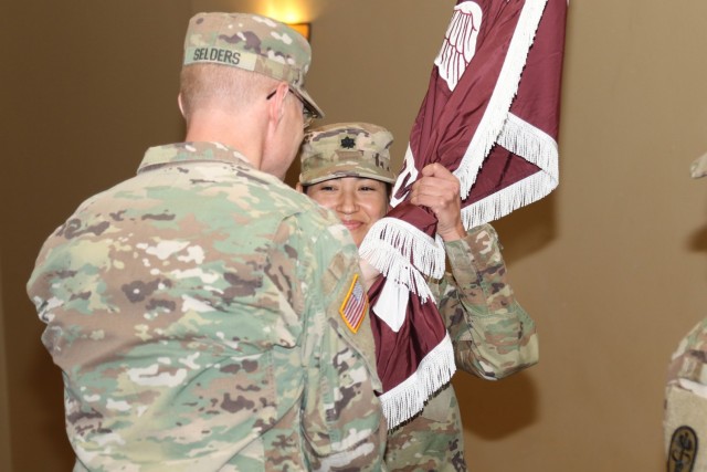 Lt. Col. Leslie Oakes, incoming commander of Fort Irwin Dental Clinic Command, receives the Fort Irwin Dental Clinic Command colors from Col. Robert Selders, Jr., commander of the Fort Carson Dental Health Activity Command, June 24 at Sandy Basin Community Center on Fort Irwin, Calif., signifying her assumption of command. Oakes, an Enterprise, Ala., native, previously served as the chief of pediatric dentistry for Fort Irwin Dental Clinic Command. (Photo by Kimberly Hackbarth/ WACH Public Affairs Office)