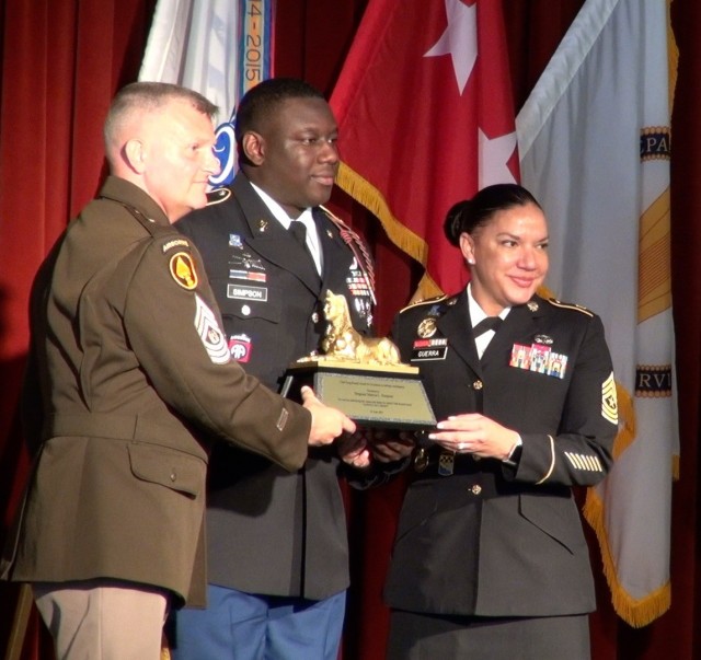 Command Sgt. Maj. Warren Robinson and (right) Sgt. Major Julie Guerra presents Staff Sgt. Marcus Simpson, the 2021 Command Sgt. Maj. Doug Russell Award for Excellence in Military Intelligence during the 2020-2021 Military Intelligence Hall of Fame...