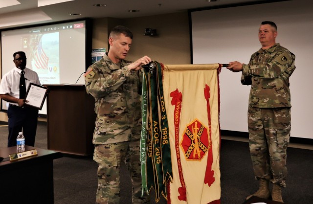 Col. CJ King connects a new streamer to the U.S. Army Garrison guidon for 12 consecutive months without any serious accidents for its fifth year in a row. The streamer, called the Safety Excellence Streamer Award, includes a unit performing 100%...