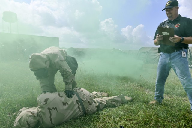 USAMTEAC Test Officer Charles Lohsandt looks on as test players wearing MOPP Level 4 protective gear test the functionality and usability of the ROCS auto-injector within the operational environment.