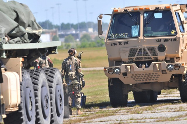 A student ground guide get set to direct a vehicle during the quartermaster culmination field training exercise June 17 at McLaney Drop Zone. The Soldier was one of a number of petroleum supply specialists who normally would “fall in” on...