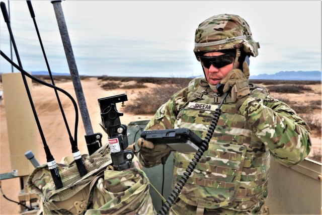 Staff Sgt. Micah Sheean, an electronic warfare specialist, communicates from atop a high mobility multipurpose wheeled vehicle. Army senior leaders discussed readiness and modernization priorities during a hearing before the House Armed Services Committee in Washington, D.C., June 29, 2021.