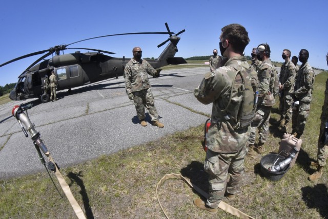 Staff Sgt. Bernard Hugison, a petroleum instructor, explains safety and refueling procedures to 92F petroleum supply specialist students during the quartermaster field training exercise June 17 at McLaney Drop Zone.