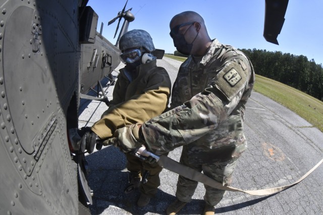 Staff Sgt. Bernard Hudgison helps Pvt. Jaelyn Belew, Uniform Company, 262nd Quartermaster Battalion to mock fuel a Black Hawk helicopter during the quartermaster field training exercise June 17 at McLaney Drop Zone.