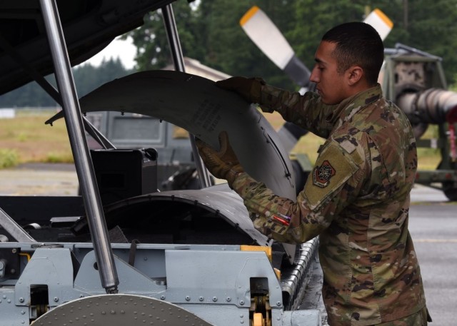 U.S. Air Force Airman Michael Lopez, 62nd Aircraft Maintenance Squadron crew chief, hands pieces of a C-130E Hercules to another Airman at Joint Base Lewis-McChord, Washington, June 12, 2021. The 62nd AMXS worked alongside several other units in...