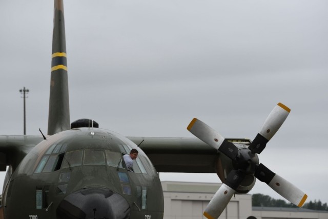 U.S. Air Force Airman 1st Class Quintin Parrott, 62nd Aircraft Maintenance Squadron crew chief, looks out of the cockpit window to ensure a C-130E Hercules propellers clear any oncoming obstacles as it is towed at Joint Base Lewis-McChord,...