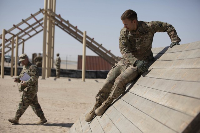 U.S. Army Spc. Omar H. Dacosta, an Infantryman with Company A, 3rd Battalion, 172nd Infantry (Mountain), 86th Brigade Infantry Combat Team (Mountain), slides down a wall during the U.S. Army Central 2021 Best Warrior Competition obstacle course...