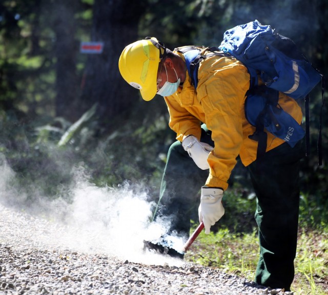 Pfc. Xavier Cha, 1st Battalion, 161st Infantry Regiment, practices with a flare during wildfire training with the Washington Department of Natural Resources June 24, 2021, in Rainier, Wash. About 250 Washington National Guard members trained on...