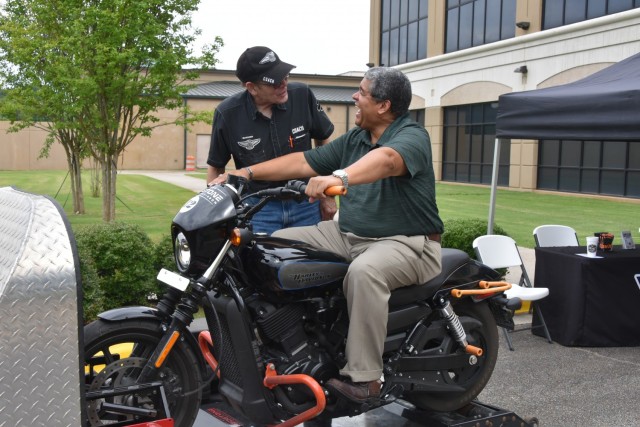 Rafael Santos, chief of the U.S. Army Space and Missile Defense Command’s Military Personnel Division, learns about motorcycle safety from Paul Walker, Redstone Harley Davidson, at the USASMDC Safety and SHARP Awareness Day at the command’s Redstone Arsenal, Alabama, headquarters June 29, 2021.