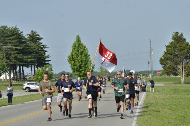 Retired Army Cpl. Phil Cook shows a memorial flag to 2nd Lt. Curt Doescher, center, and 2nd Lt. Edward Li, right, both with 1st Squadron, 75th Cavalry Regiment, 2nd Brigade Combat Team, 101st Airborne Division (Air Assault), after finishing the...
