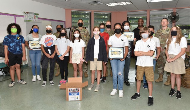 Antilles Middles School seventh graders proudly display their Fort Buchanan Garrison Certificates of Appreciation presented by garrison leadership for their commendable initiative in support of our deployed troops, jUNE 15, 2021.