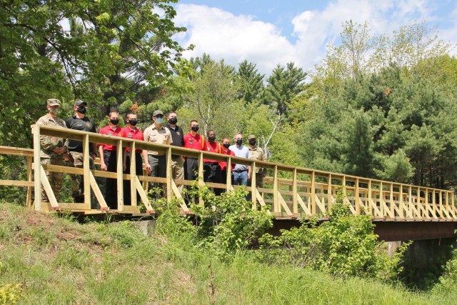 Members of the garrison command team, cadets and staff members with the Challenge Academy, and Boy Scout Derek Poss stand on the newly restored bridge over Tarr Creek June 1, 2021, at Fort McCoy, Wis. Poss helped coordinate the restoration as an...