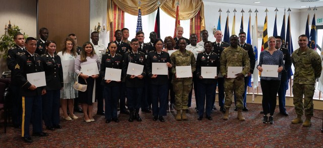 After taking the Oath of Allegiance to the United States, 25 new Americans presented their naturalization certificates together with USAG Bavaria Garrison Commander Col. Christopher Danbeck (third row, second from right) and incoming garrison Command Sgt. Maj. Sebastian Camacho (first row, far right), June 30, 2021. (U.S. Army photo by Andreas Kreuzer / USAG Bavaria)