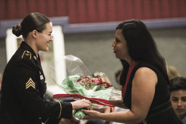 Karen Bell receives a bouquet of flowers as her husband, Col. Jeremy D. Bell, outgoing Fort Campbell garrison commander, prepares to relinquish command June 28 during a ceremony in Wilson Theater.