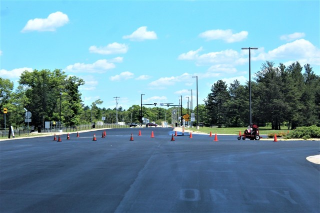 Work by contractors with Scott Construction of Lake Delton, Wis., for seal-coating work is shown on the roadway near the Main Gate on June 2, 2021, at Fort McCoy, Wis. The project, coordinated by the Fort McCoy Directorate of Public Works,...