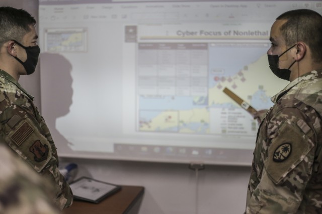 Spc. Avery Tyquienco, Intelligence Analyst in the Guam National Guard, right, develops a cyber map overlay in support of Exercise Orient Shield 21-2 in Dededo, Guam on June 30. The annual exercise, conducted between the Japanese Ground Self...