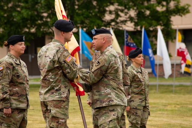 Colonel Jon Brierton from Fort Dix, passes the garrison colors to incoming Garrison Commander Lieutenant Colonel Trent Colestock. Also pictured Garrison Command Sergeant Major Jamie Rogers, and outgoing Garrison Command Sergeant Major Kelli Harr.