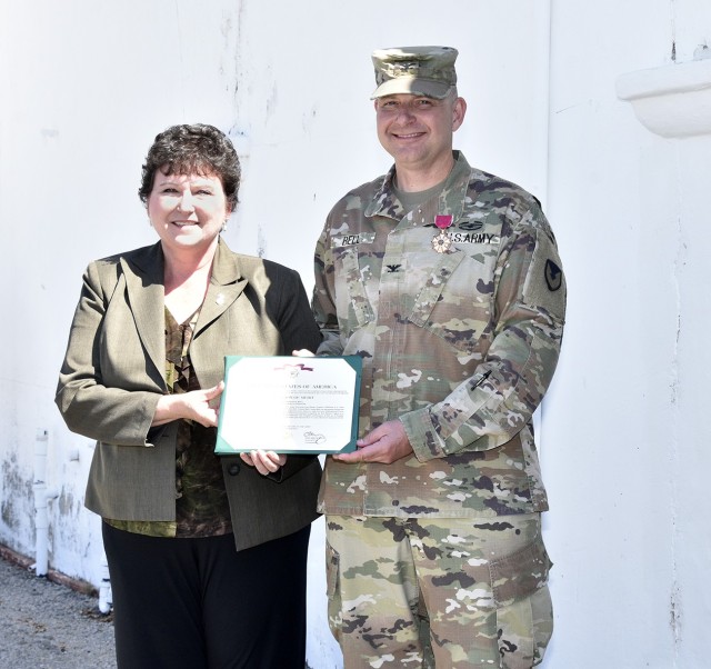 Col. Charles R. Bell, Jr. received the Legion of Merit Award from Brenda Lee McCullough, IMCOM-Readiness Director, prior to the Change of Command Ceremony between outgoing garrison commander Col. Charles R. Bell Jr. and incoming commander Col....