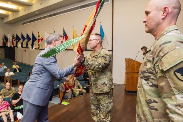 Lt.  Col. Andrew White accepts the unit colors to assume command of U.S. Army Garrison Natick from Mr. Vincent Grewatz Director of Installation Management Command - Training Directorate on July 1, 2021. (U.S. Army photo by David Kamm)