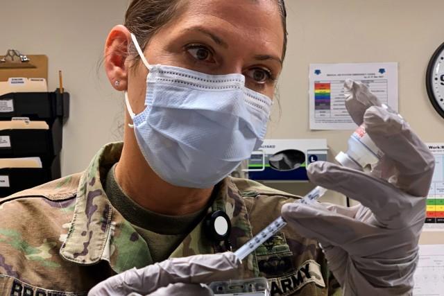Maj. Jodi Brown, Chief of Public Health at the California Medical Detachment, prepares syringes for the paramedics administering the Moderna COVID-19 vaccine, March 23, 2021.