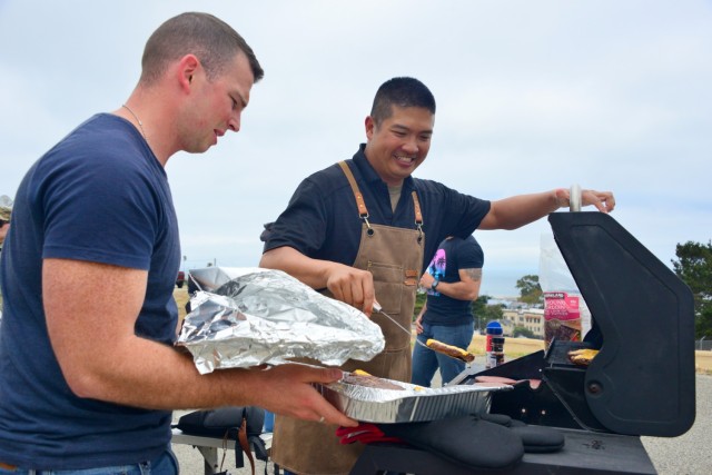 Sgt. 1st Class Solomon Chan, right, assigned to the 229th Military Intelligence Battalion, serves up cheeseburgers during the battalion’s Cadre Appreciation Day at Presidio of Monterey, Calif., July 1. Chaplain (Capt.) Jordan Dersch stands left.