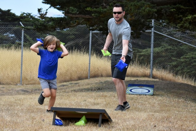 Dylan Farnsworth and his son Nolan, 6, play corn hole during the battalion’s Cadre Appreciation Day at Presidio of Monterey, Calif., July 1.