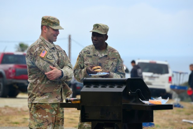 Chaplain (Capt.) Yaw Agbenu, right, and Maj. Steve Gluck talk as they oversee a grill during the 229th Military Intelligence Battalion’s Cadre Appreciation Day at Presidio of Monterey, Calif., July 1.