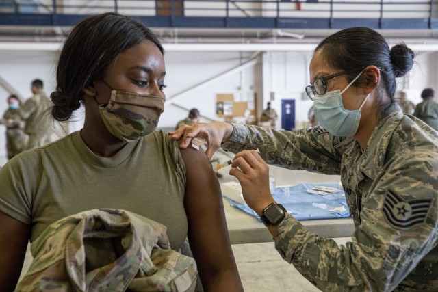 U.S. Army Sgt. Kendra Hallett, left, receives the Covid-19 vaccine from U.S. Air Force Tech. Sgt. Deborah Macalalad 108th Medical Group, New Jersey Air National Guard, on Joint Base McGuire-Dix-Lakehurst, N.J., Feb. 21, 2021. (U.S. Air National...