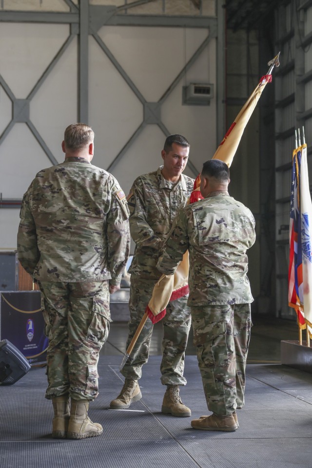 U.S. Army Garrison-Kwajalein Atoll Commander Col. Thomas Pugsley, center, and outgoing Col. Jeremy Bartel, left, return the USAG-KA unit colors to Command Sgt. Maj. Ismael Ortega, right, at the USAG-KA Change of Command Ceremony June 30, 2021.