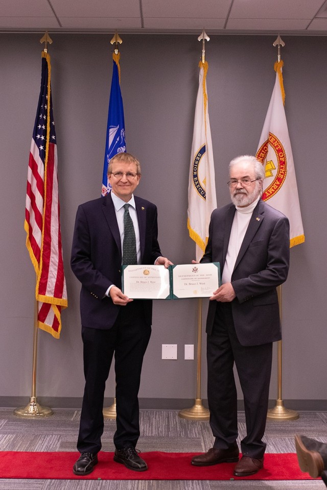 Dr. Patrick Baker, DEVCOM ARL director (left) presents Dr. Bruce J. West, senior research scientist in mathematics for the U.S. Armuy with a certificate of appreciation as West retires with more than 22 years of federal service. 