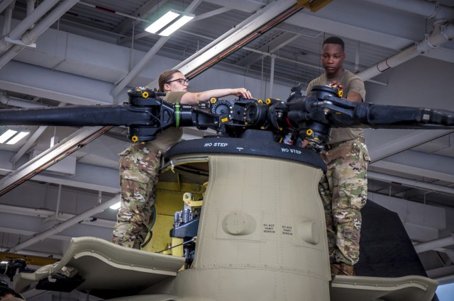 U.S. Army Spc. Kaitlin Cavanaugh and Sgt. Omar Sewell conduct maintenance on the forward rotor of a CH-47 Chinook helicopter that was battle damaged from a hard landing while serving in Iraq in the maintenance bay of the Connecticut National Guard's 1109th Theater Aviation Support Maintenance Group in Groton, Conn. June 22, 2021. The TASMG recovered this helicopter from Kuwait and performed a complete overhaul of the aircraft in order to get it back into the Army's operational fleet.