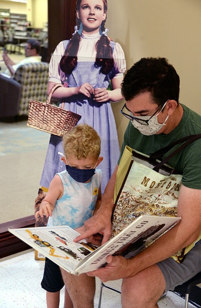 Chris Norman and his 3-year-old son Rex peruse "The Big Book of Things That Go" July 6 in the children's room of the Combined Arms Research Library. The family had participated last fall in the StoryWalks positioned outside the library, but this...