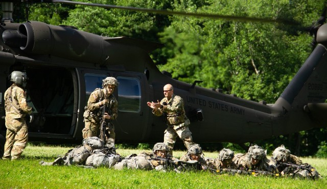 Capt. Curt Lane (Right, standing) directed Class of 2024 cadets as they exit the helicopter at Landing Zone OWL and get in defensive positions on the last day of the field training exercise June 23 at Camp Buckner.