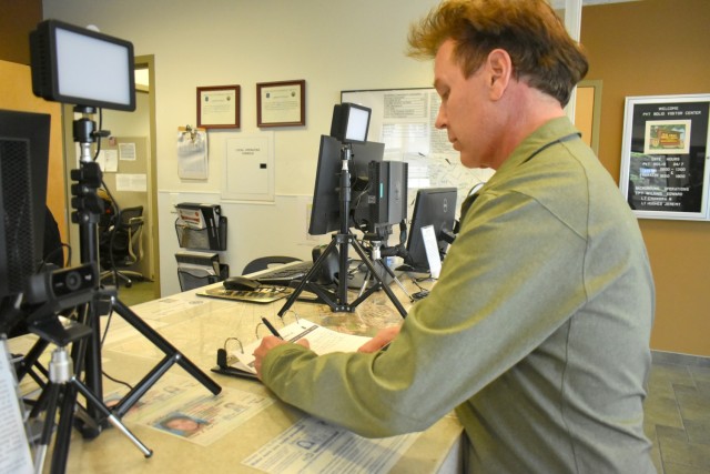 Gwyn De Amaral, a Gold Star survivor, signs for his new Survivor Access Badge at the Visitors Center, Presidio of Monterey, Calif., June 29.