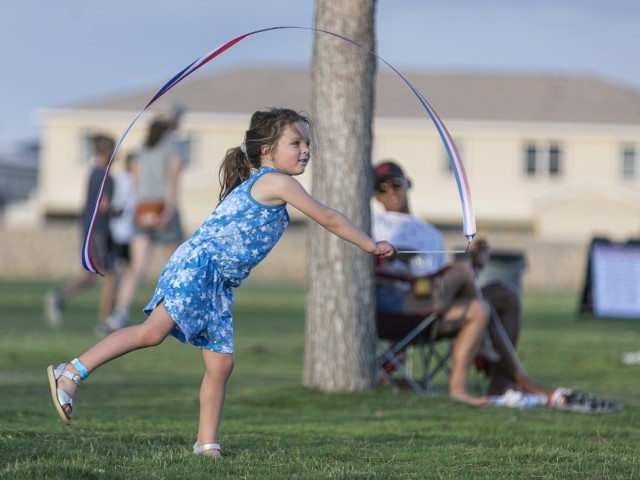 Army kid Liesel Dixon, 5, daughter of Capt. Christopher Dixon of the 1st Armored Division, celebrates Independence Day with a streamer at Pop Goes the Fort, the on-post Independence Day celebration, at Fort Bliss, Texas, July 4, 2021.