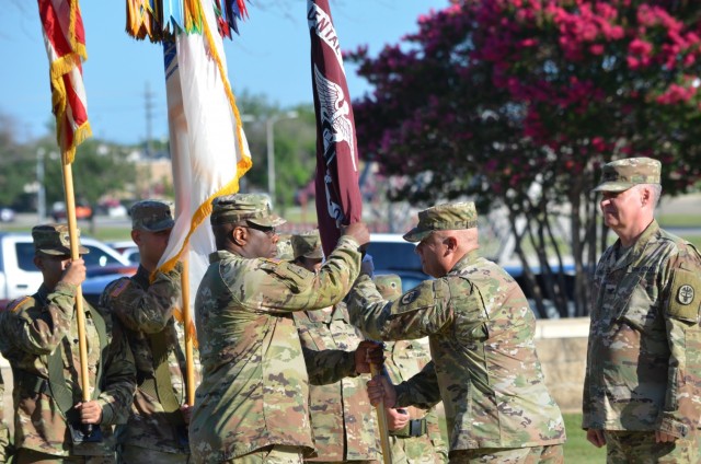 Fort Hood, Texas – Col. Paul Colthirst, commander, U.S. Army Fort Hood Dental Health Activity receives the guidon from Col. Rafael Caraballo, commander, Dental Health Command-Central during a change of command ceremony in which he to command from Col. Stefan Olpinski on Hildner Field July 1.