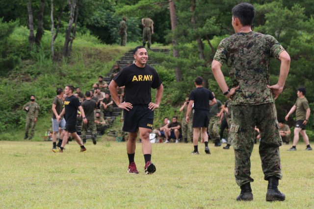 A Soldier assigned to 1st Battalion, 28th Infantry Regiment, 3rd Infantry Division, shares a laugh with a member of the Japan Ground Self-Defense Force during an ultimate Frisbee tournament between Soldiers assigned to 1st Battalion, 28th Infantry Regiment, 3rd Infantry Division, and JGSDF members on Aibano Training Area, Japan, July 2, 2021. Soldiers and members of the JGSDF participated in the tournament in a short break from training during exercise Orient Shield. Orient Shield is the largest U.S. Army and JGSDF bilateral field training exercise being executed in various locations throughout Japan to enhance interoperability and test and refine multi-domain and cross-domain operations.