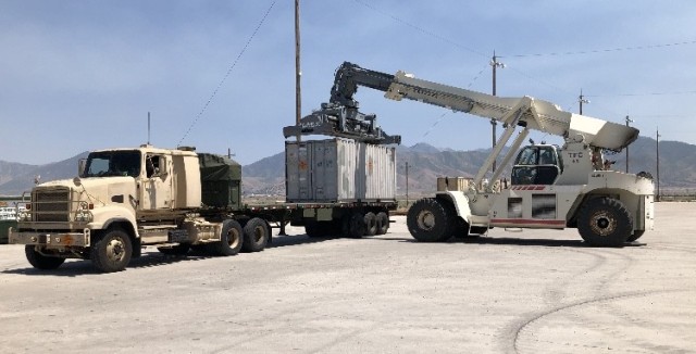 Container Handler removes milvan full of munitions from truck at Tooele Army Depot.