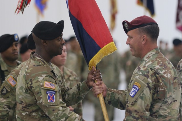 Lt. Gen. Michael E. Kurilla, XVIII Airborne Corps commander (right), passes the 10th Mountain Division (LI) colors to Brig. Gen. Milford Beagle Jr., during the division change of command ceremony July 12 at Wheeler-Sack Army Airfield. (Photo by Sgt. Brandon Cox, 10th Mountain Sustainment Brigade Public Affairs)