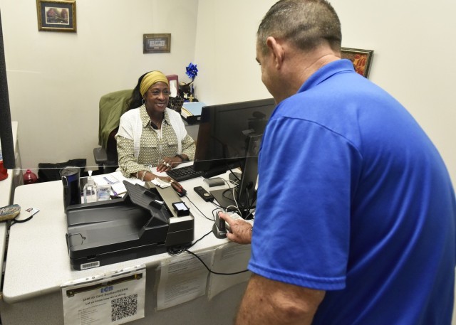 Konnye Porter, a human resources assistant at Fort Leonard Wood’s Defense Enrollment Eligibility Reporting System, or DEERS, ID card office, helps a customer July 13. Office staff have worked this year to improve the experiences of their customers.