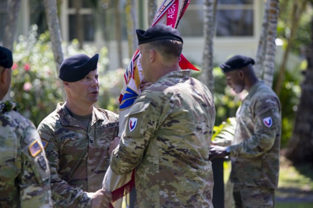 402nd Army Field Support Brigade's incoming commander, Col. Erik C. Johnson passes the brigade's colors to Command Sgt. Maj. Adam Lepley during the change of command ceremony on July 9, 2021.